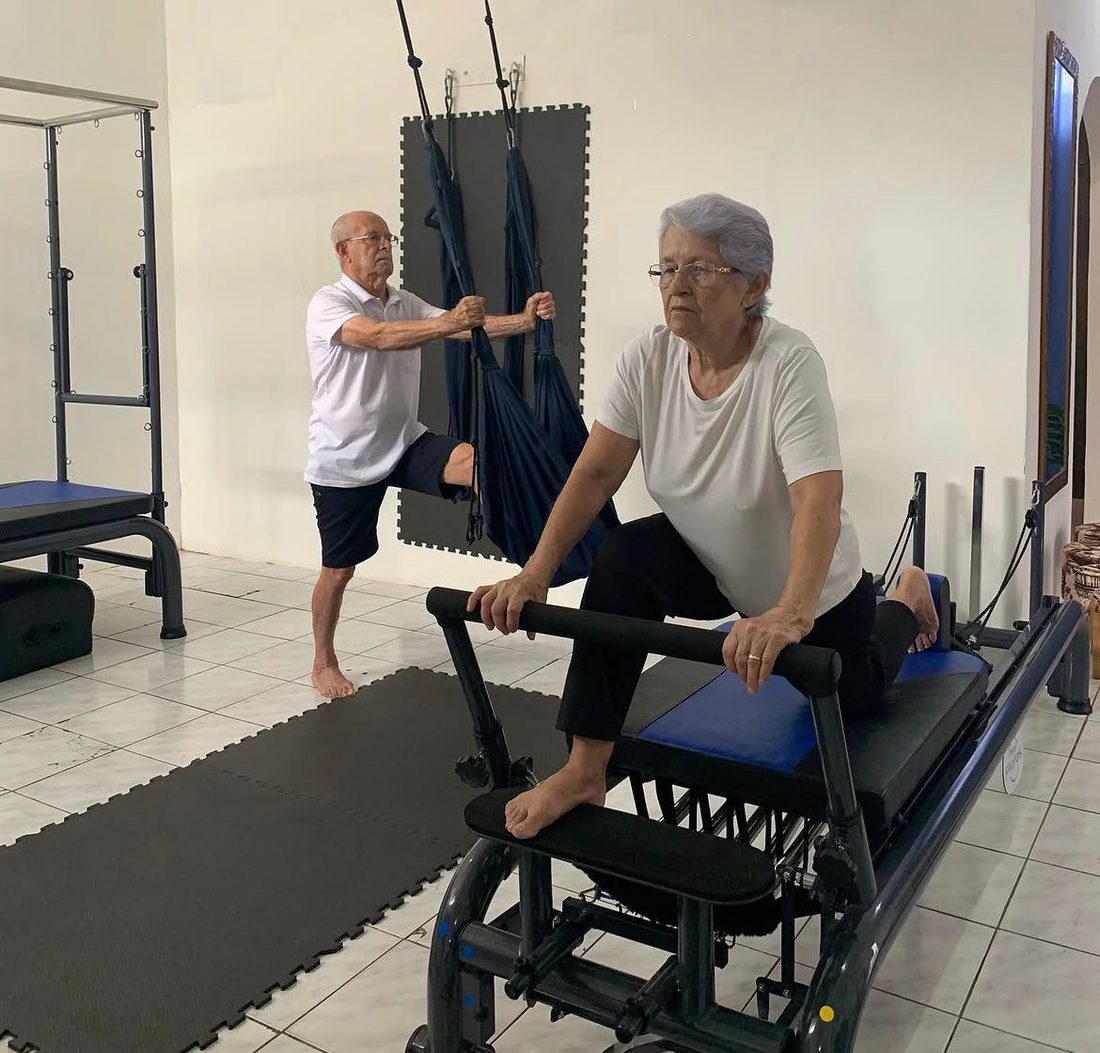 Casal da melhor idade em aula de Pilates nos aparelhos